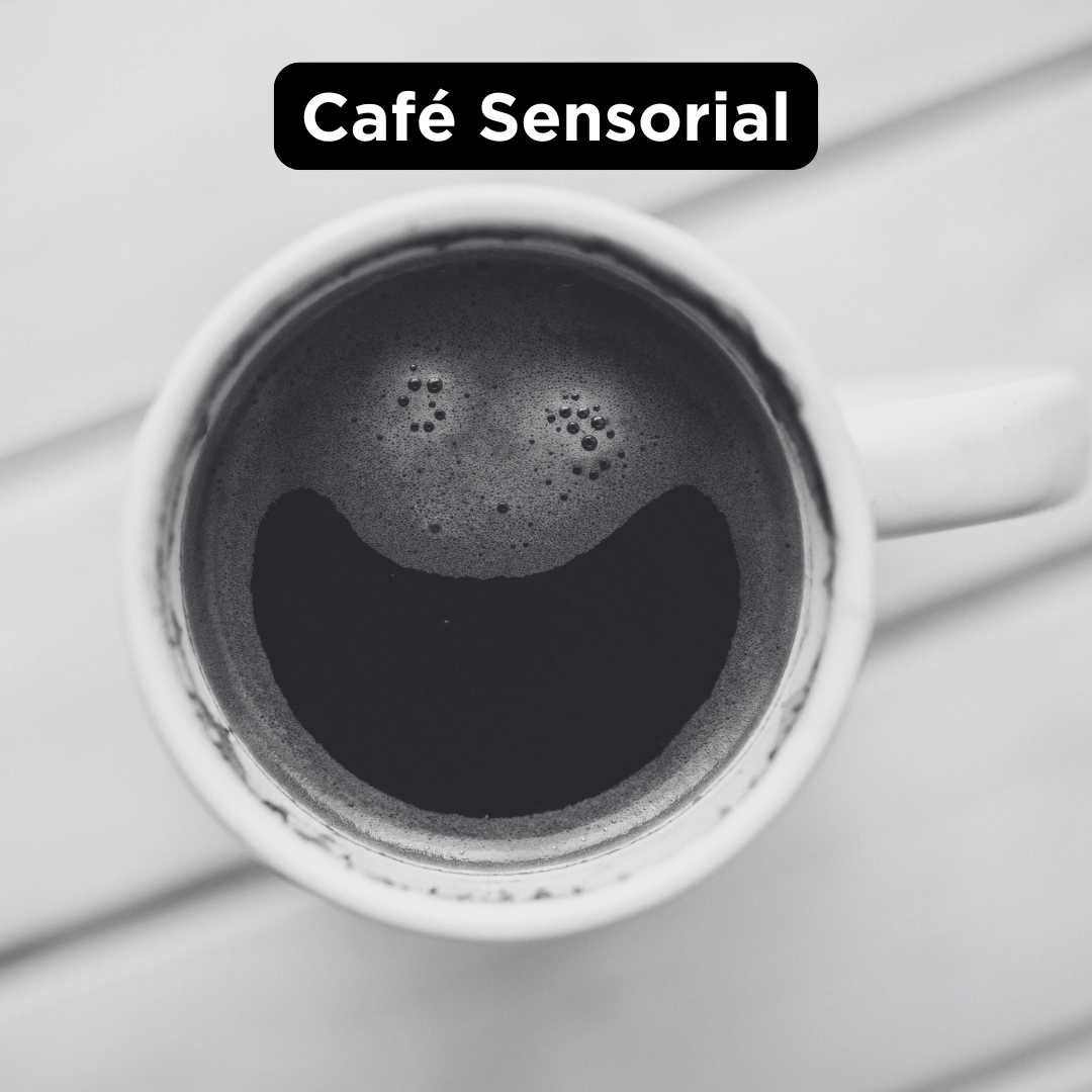 vista de cima pra baixo de uma xícara branca de café. A espuma forma uma carinha feliz.