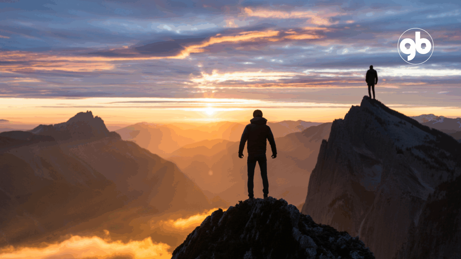 Silhueta humana no topo de uma montanha durante o nascer do sol. Ao fundo e à direita, uma outra pessoa no cume de outra montanha.