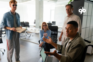 Quatro pessoas em reunião, sendo uma cega e outra em cadeira de rodas.
