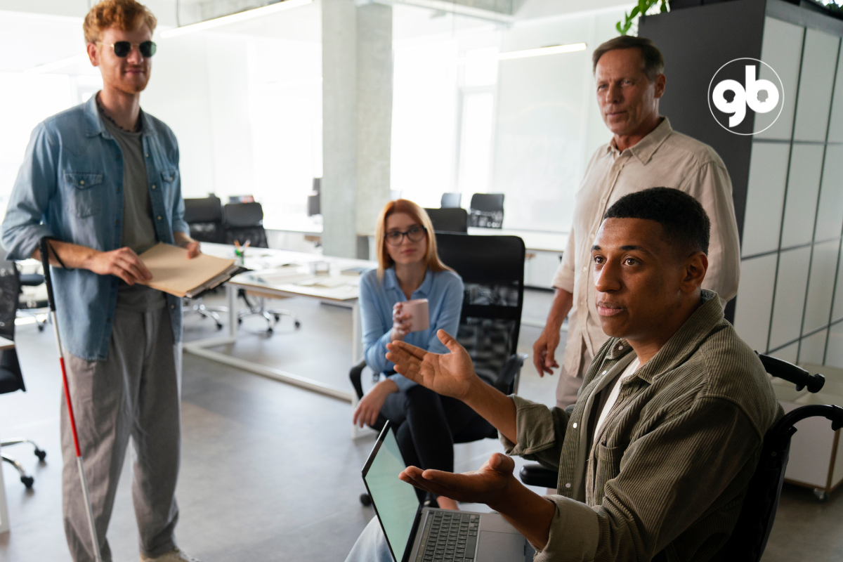 Quatro pessoas em reunião, sendo uma cega e outra em cadeira de rodas.
